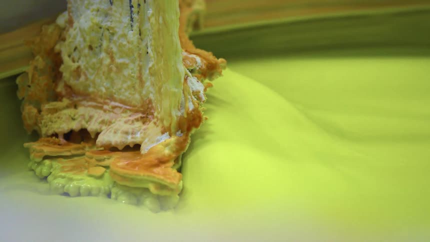 Lime green liquid being mixed in a vat