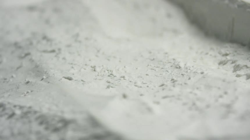 Hand running through white powder