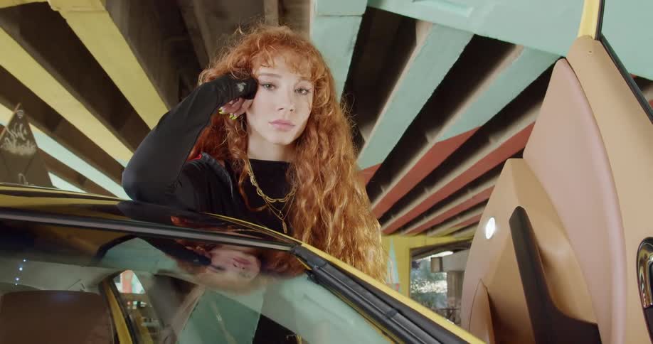 A woman is standing by a parked car