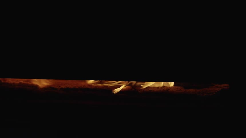 Doors closing on the yellow flames inside a furnace forge