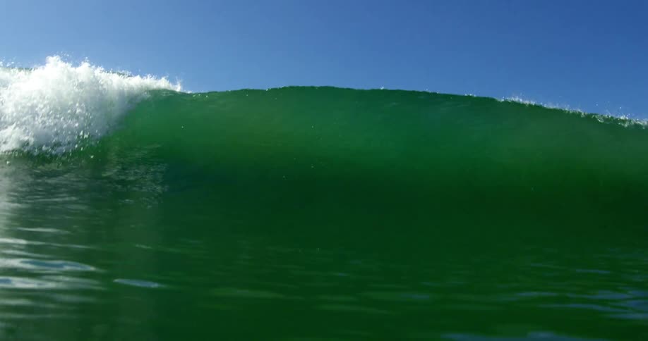Glassy wave in the ocean crashing into camera lens