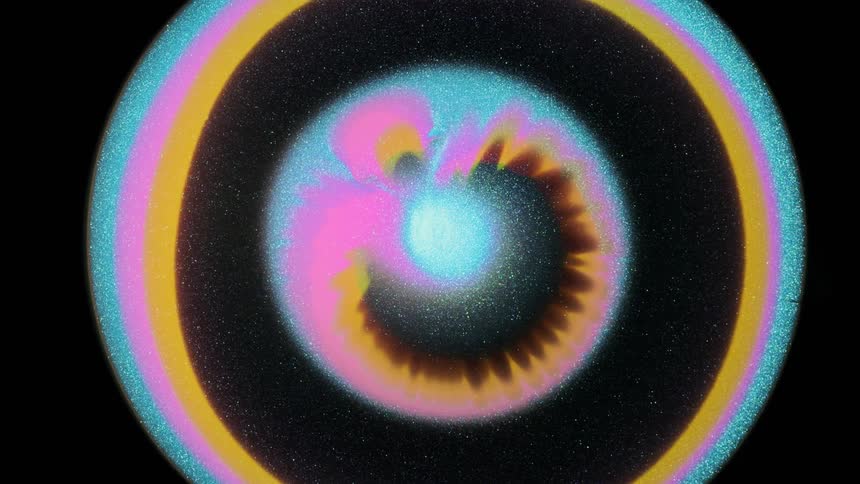 A ring of orange pink and blue glitter exploding outwards