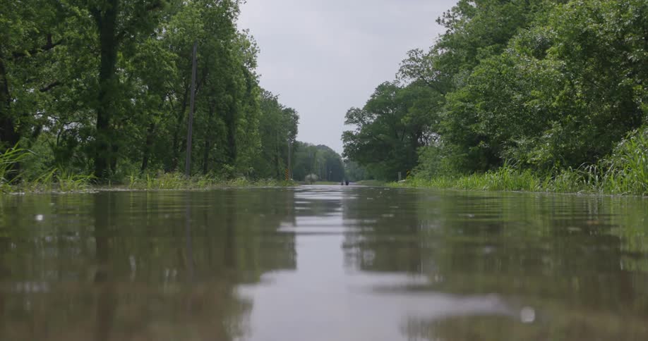 A low shot of rippling water of a severely flooded roadway when the Arkansas River overflowed its banks in spring