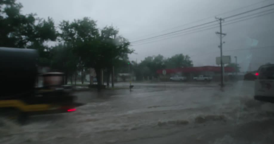 Looking out the window as the vehicle drives through very flooded roads after a huge thunderstorm dropped high rainfall totals
