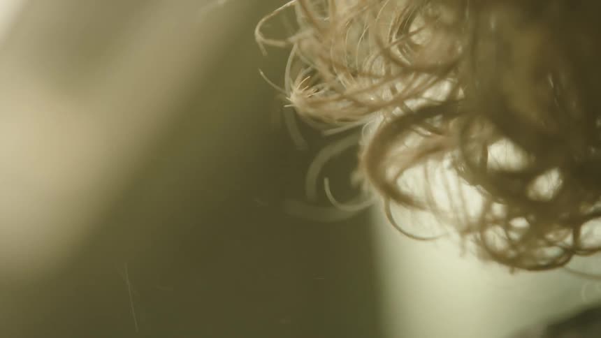 Tight shot of a man with a silver curly hair and a silver beard riding in an SUV while storm chasing in rural America