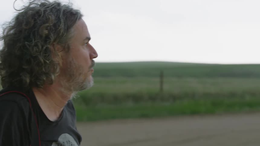 Middle Aged Man intensely scans the skyline for tornados, lightning and other hazards while storm chasing in Texas