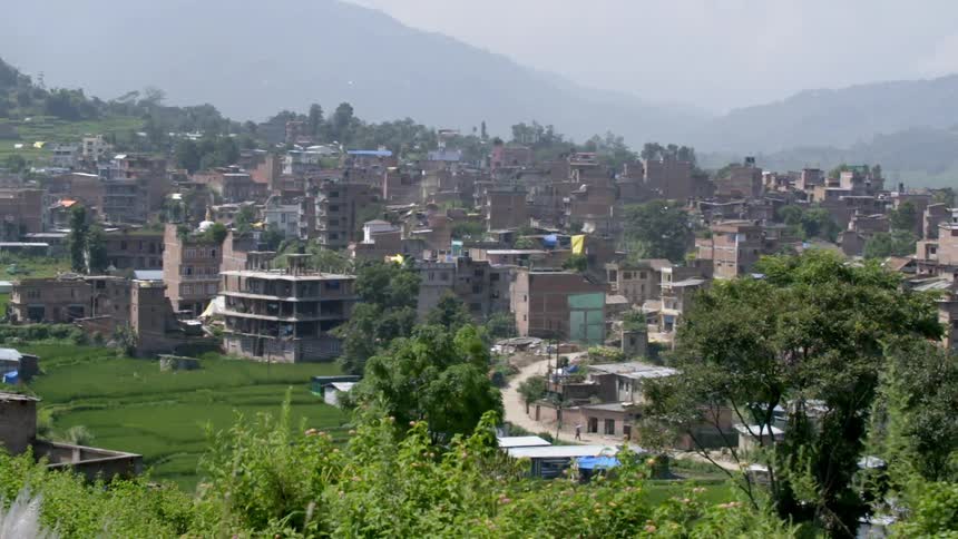 View of a city from a moving vehicle upon a hill