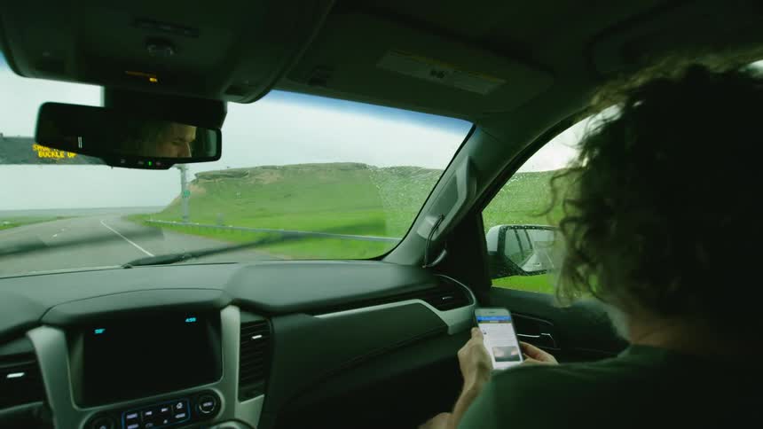 Storm chasers check the weather while driving to the next super cell thunderstorm