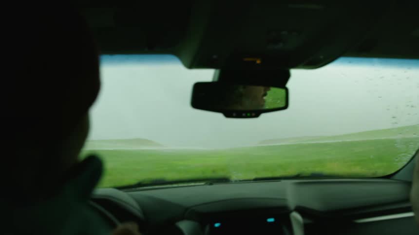 People escaping from a tornado go off road to avoid a traffic jam under a bridge with large hail hitting the windshield of the stormchasers vehicle