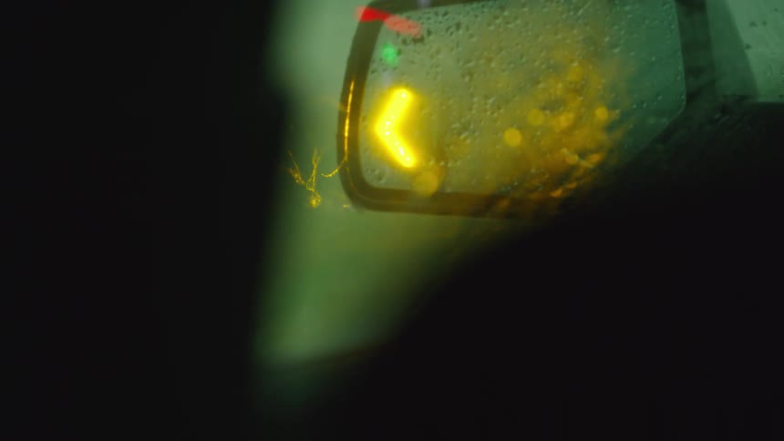 Real time shot of intense heavy rain fall being illuminated by the side mirror hazard lights flashing