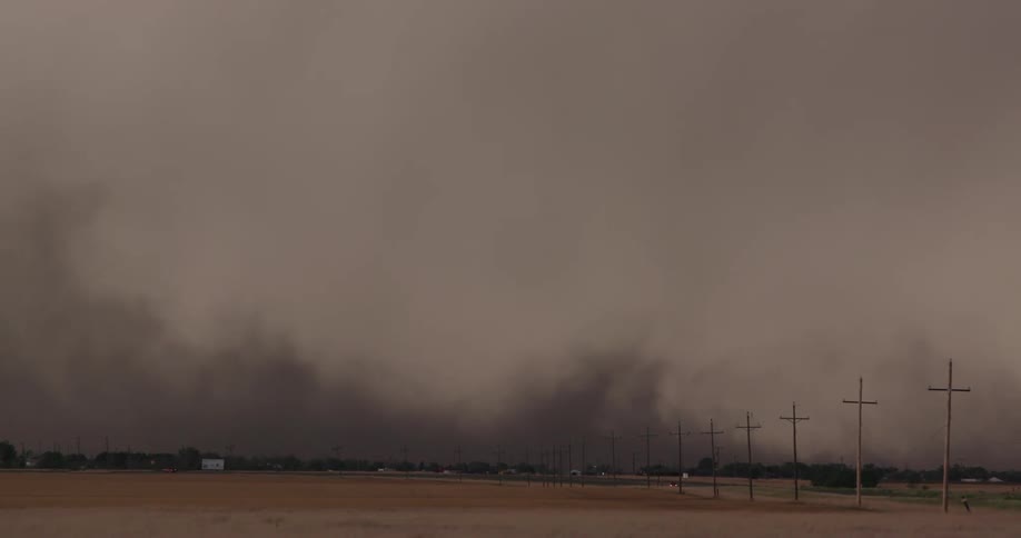 Real time shot of severe winds blowing sand and dust across a rural highway during a severe thunderstorm in rural Texas