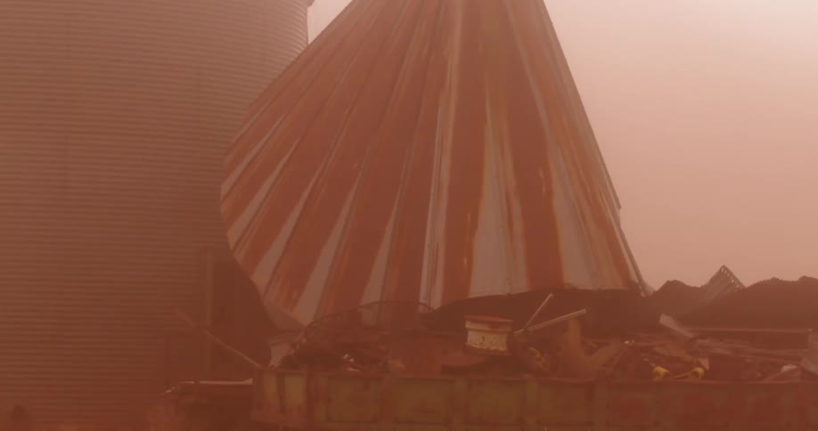 A strong Haboob dust storm overwhelms a steel silo as strong winds blow debris around this severe weather lunar landscape