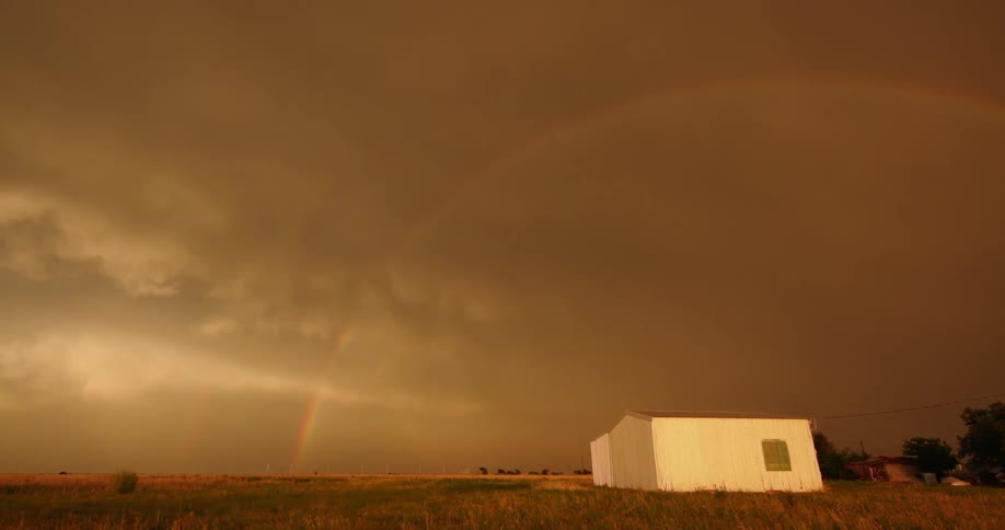 Stunning time lapse post thunderstorm of mammatus clouds just before a brilliant rainbow arcs across the storm cloud filled sky