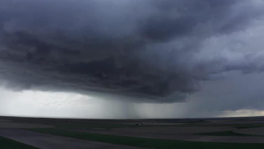 Aerial time lapse of a huge super cell thunderstorm blowing across rural agricultural land dumping an incredible amount of rain as it churns towards camera