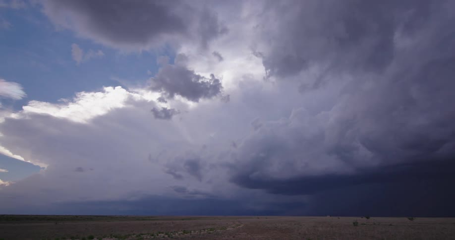 Time lapse of a massive supercell anvil thunderstorm as it builds and gains strength over the New Mexican arid desert with massive lightning bolts on the right side of the frame