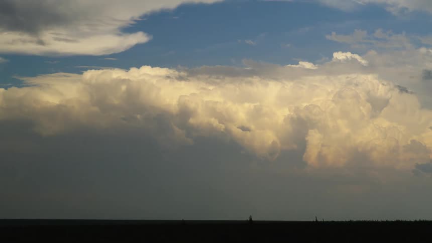 Time lapse of distant severe thunderstorm boils and builds as the sun sets revealing beautiful sunset cumulous clouds