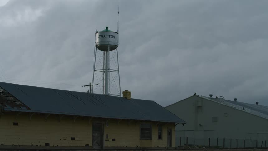 Time lapse of a massive wall cloud severe thunderstorm system approaching a small town water tower before rapidly overwhelming the camera in darkness