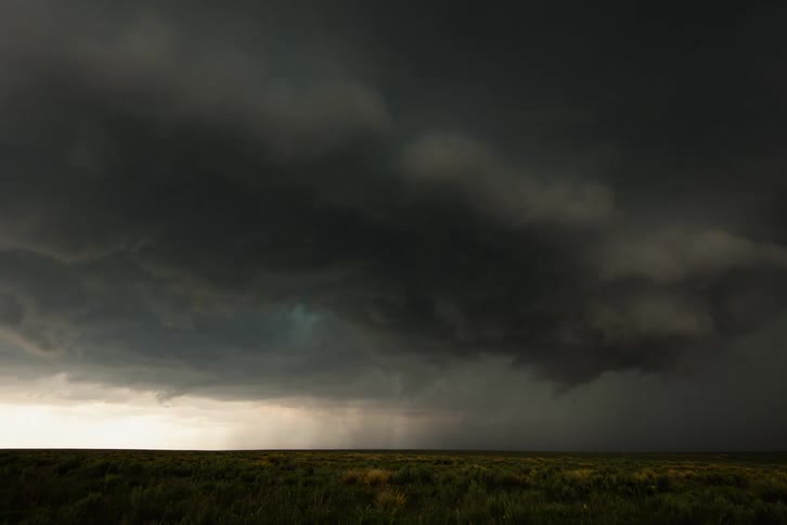 Time lapse of a ominous and churning supercell thunderstorm severe weather system as it rotates and considers producing a tornado before passing the camera