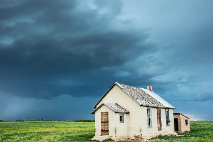 Time lapse of a rural and abandoned schoolhouse in eastern Colorado with  severe thundestorm clouds churning and boiling in the background