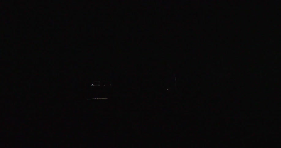 Real time shot of intense lightning illuminating grain silos deep in rural America at night