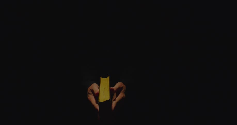 An open book has flames coming off of its pages until it is closed by the person holding it