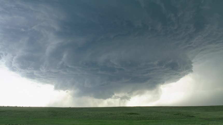Real time hand held shot of an impossibly ominous super cell storm as lightning flashes and crashes into the ground