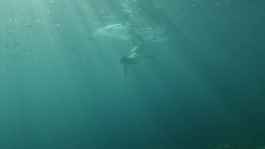 A woman swimming underwater with fish