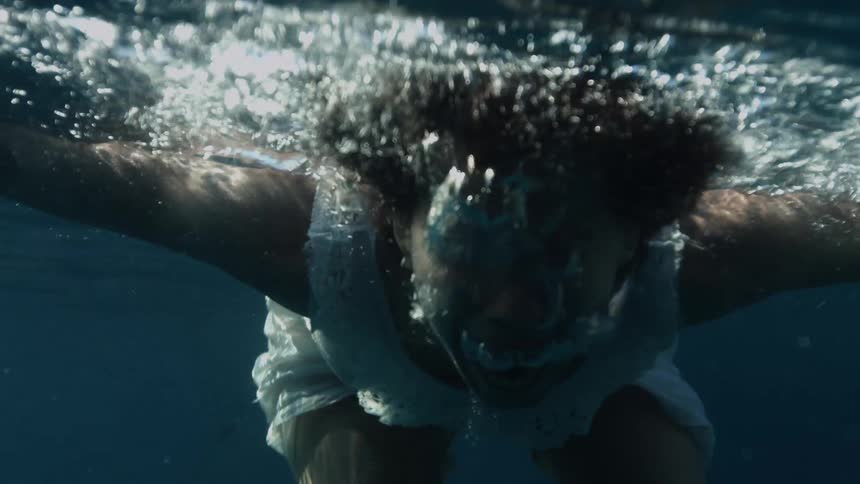 Woman floats and swims under water then comes up