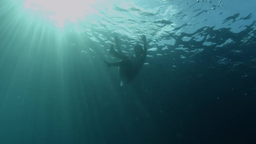 Woman floating underwater in the ocean