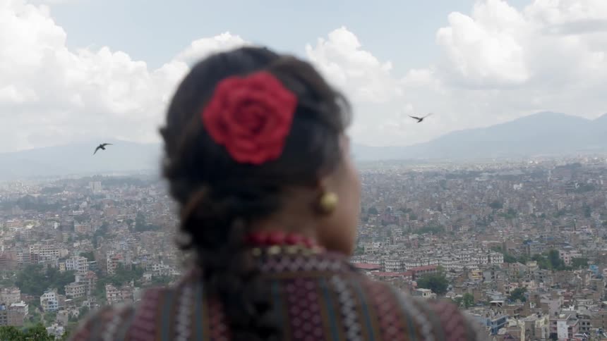A woman overlooking a city near the mountains