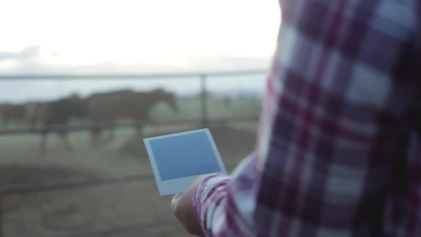 Blonde woman takes a picture of grandfather and granddaughter with a horse in the farm