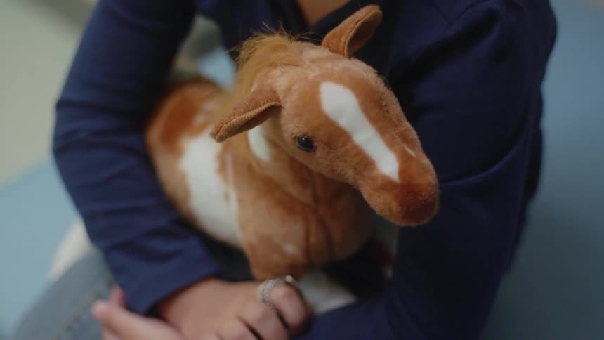 A person with a ring holding a stuffed toy