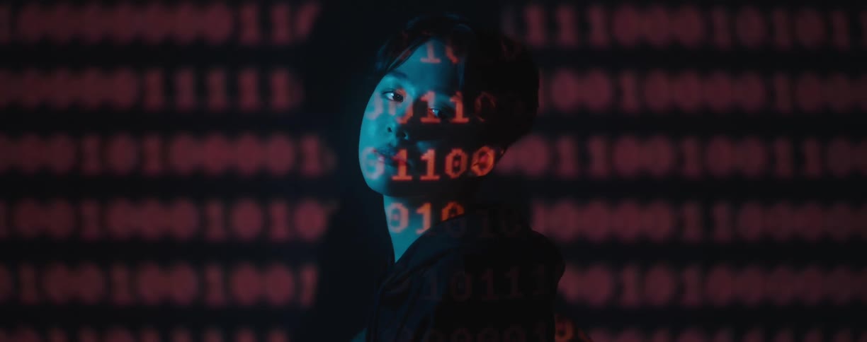 Red text projected over the face of a young woman in a dark room