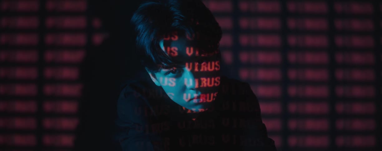 A man is in a room and text is written in the background