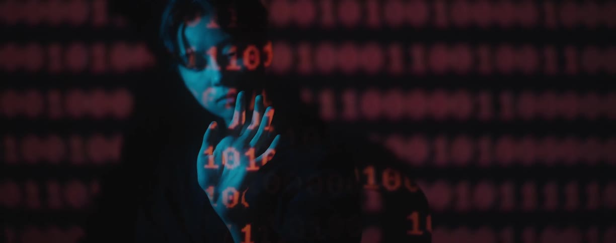 Woman waving her hand around red binary digits from a projector