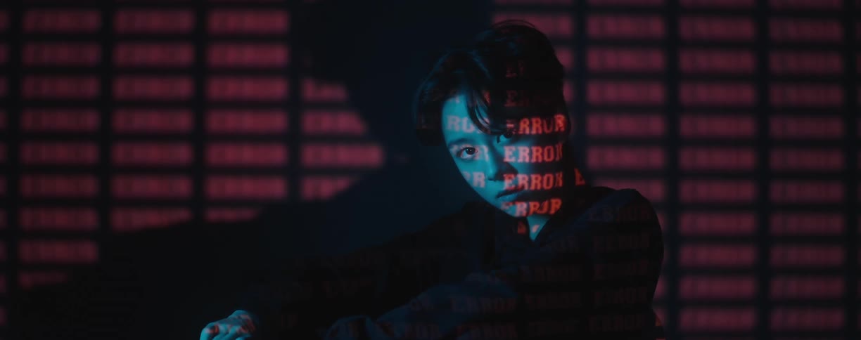 A model poses in front of a large screen with the word error displayed repeatedly
