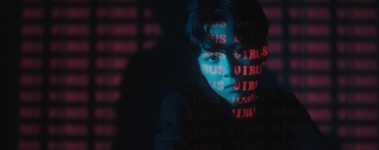 A man is sitting on the ground in a room with text
