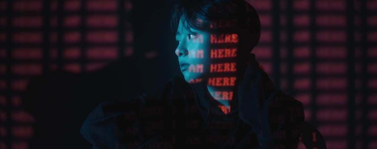 A teenage boy modeling with text shining on his face