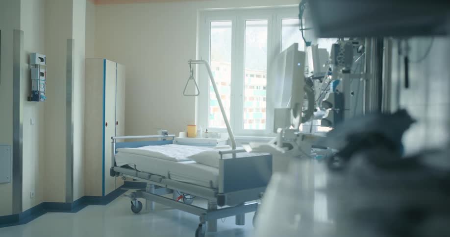 An empty hospital bed in a hospital room