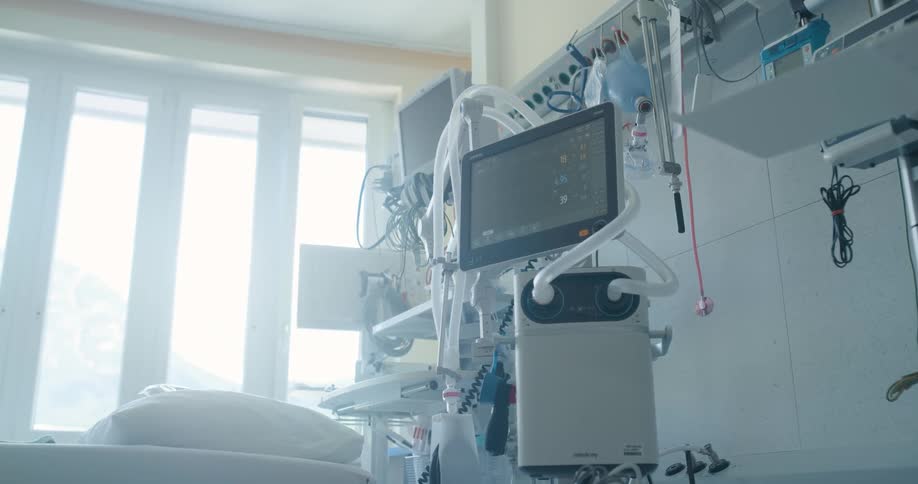 Multiple pieces of medical equipment are located near a hospital bed