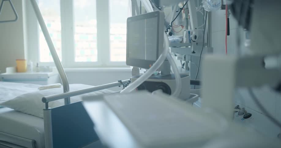 Medical equipment next to an empty bed in a hospital room