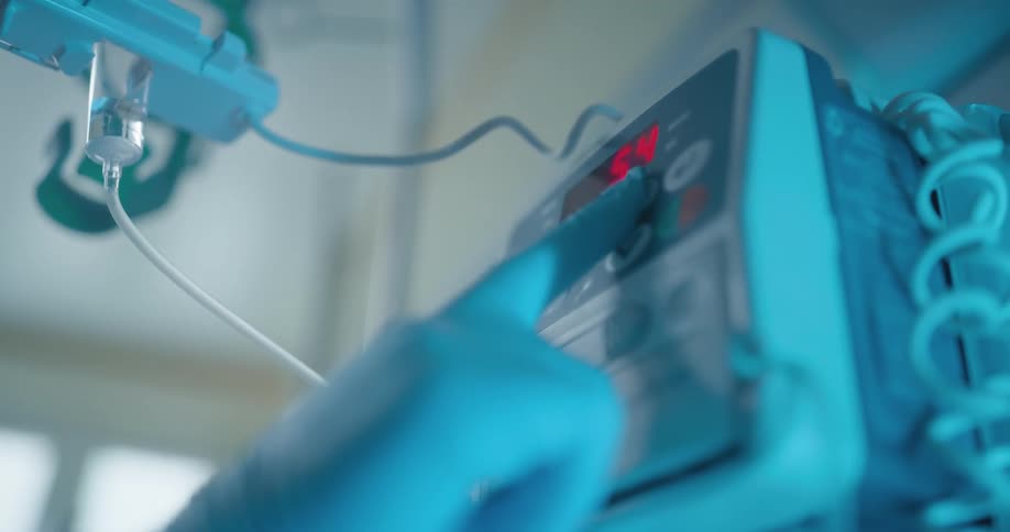 A nurse pushing a button on medical equipment