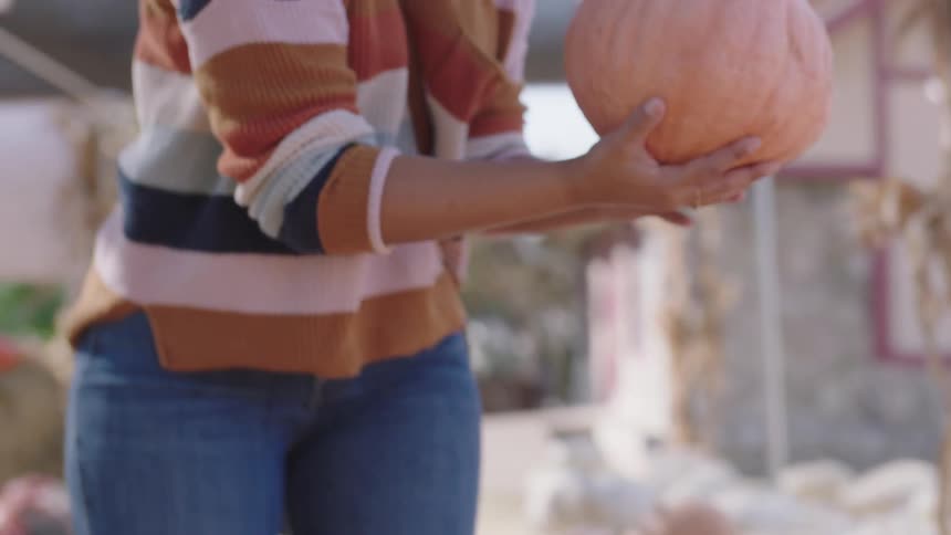 Young woman buying pumpkins in an outdoors public market