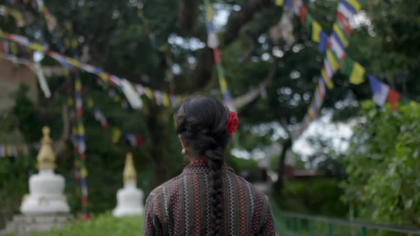 A woman is walking under strings of flags above her
