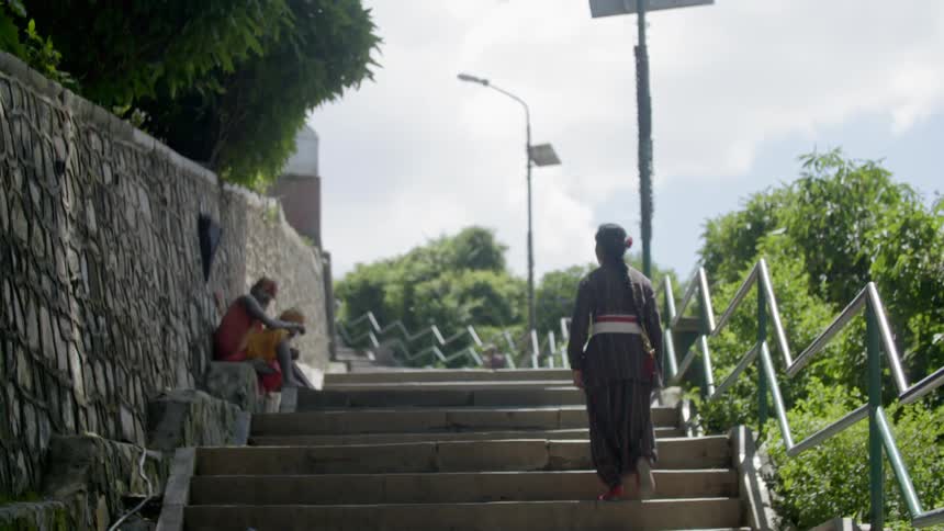 Asian woman ascending some stairs on a cloudy day