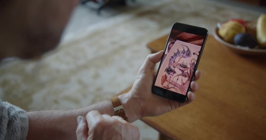 Woman showing her drawings to a friend through the phone