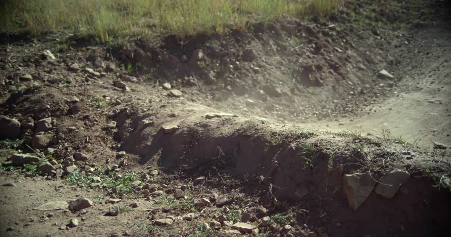 A person mountain bikes on a dirt trail