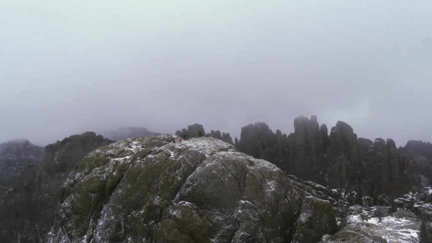An aerial view of people standing on a mountain top