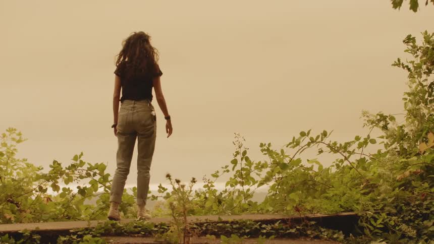 A woman jumping up and looking into the distance