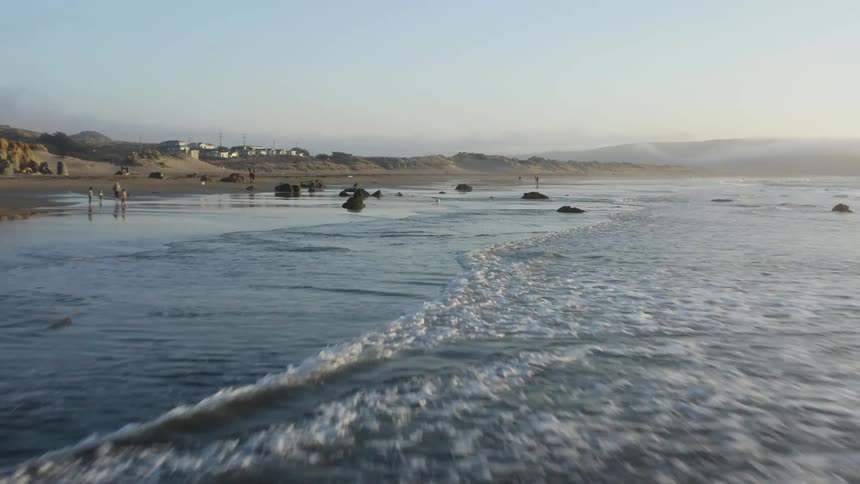 Aerial view of the rising tide on the coast near a small town